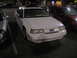 2002 Ford Taurus - A white sedan is parked in a lot at night, next to another vehicle.