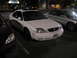 2002 Ford Taurus - A white sedan with a sunroof is parked in a lot at night. The license plate is visible and reads NYK117.