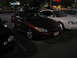 2002 Ford Taurus - A red Ford Taurus is parked in a lot at night, with a white car beside it.