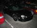 2002 Ford Taurus - A black sedan is parked in a lot at night, with other vehicles nearby. The car has custom wheels and stickers.