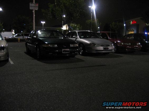2002 Ford Taurus parked at night, front view. Other cars visible
