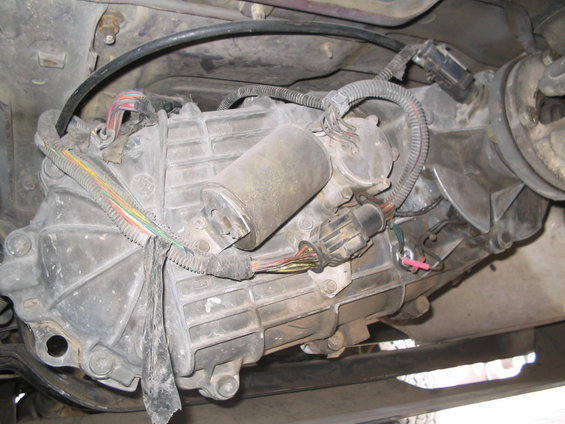 Underside view of a vehicle's transfer case and transmission with wiring harnesses