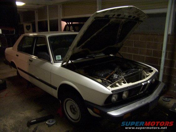 White sedan with hood open, showing engine bay