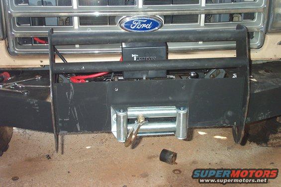 Ford truck front end with a black bull bar and winch, showing a "T-MAX" label and red cables