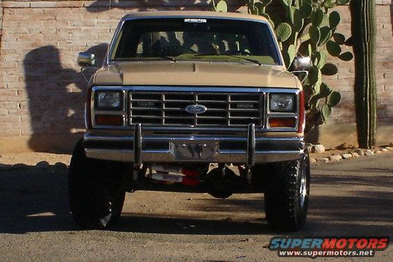 Tan Ford Bronco with lifted suspension and large tires, front view