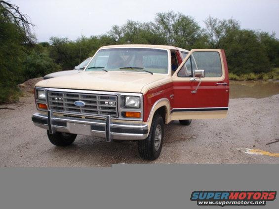 Two-tone red and tan SUV with front doors open, showing interior