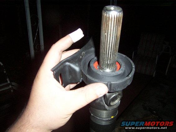 Hand holding a driveshaft U-joint and yoke with a splined shaft