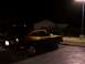 1978 Ford Mustang II - A two-tone Ford Mustang II is parked in a lot under a street light at night.