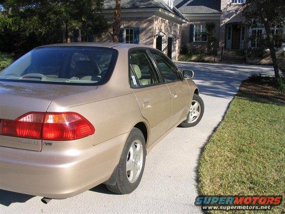 2000 Honda Accord sedan, tan color, parked on a concrete driveway in front of a brick house