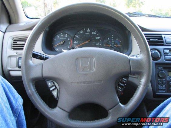 Gray steering wheel and dashboard of a 2000 Honda Accord, showing the instrument cluster and radio