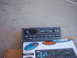 1978 Ford Bronco - A car stereo unit is placed on top of a box that advertises car audio equipment.