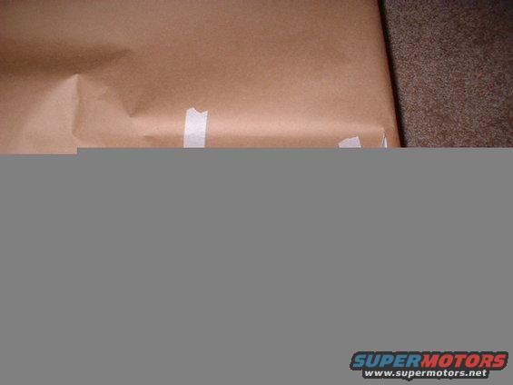 brown paper taped shut on a carpeted surface