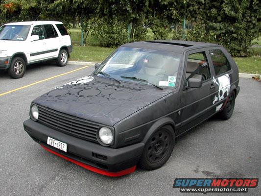 Black hatchback with skull graphics on hood and side, red front lip, black wheels