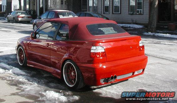 Red convertible Volkswagen Golf with custom body kit and dual exhaust pipes