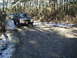 1979 Ford Bronco II - A Ford Bronco navigates a muddy path through a wooded area, with a second vehicle following closely.