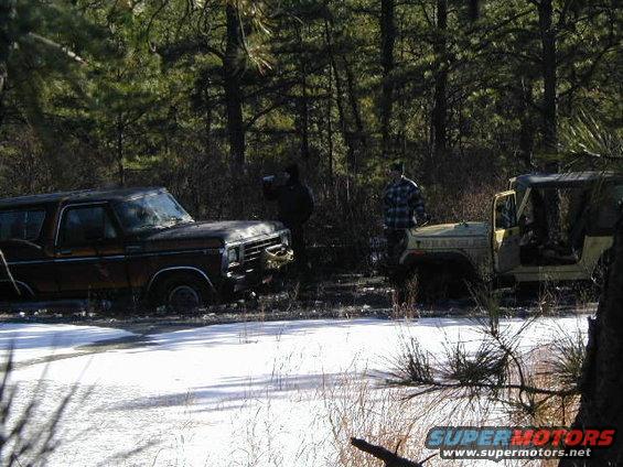 Brown 1979 Ford Bronco parked in snow, facing left. Another Jeep is to its right