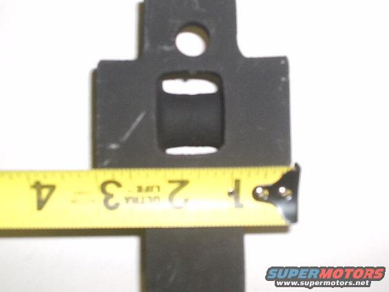 Measuring a black metal shackle mount with a yellow tape measure