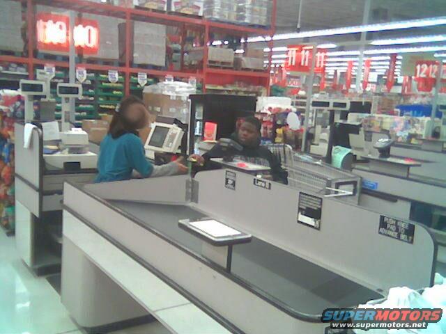 Grocery store checkout lanes with cashiers and customers