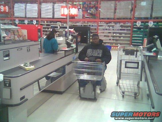 Person in motorized shopping cart at checkout lane in a store