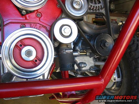 Close-up of red engine block with pulleys and belts