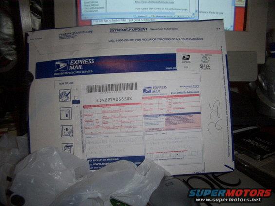 USPS Express Mail envelope with handwritten notes and shipping labels