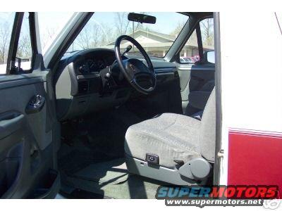 Interior view of a truck cab, showing the driver's seat, steering wheel, and dashboard