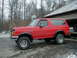 1990 Ford Bronco - Red 1990 Ford Bronco parked outside a garage in winter conditions.