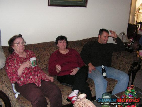 Three people relaxing on a couch during a holiday gathering