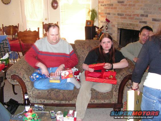 People opening gifts on a couch during Christmas