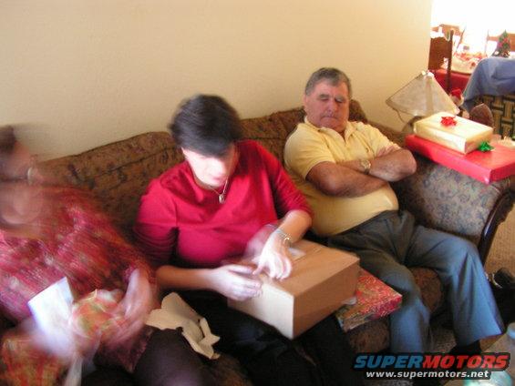 People opening Christmas presents on a couch