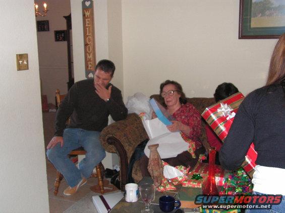 People opening Christmas gifts in a living room