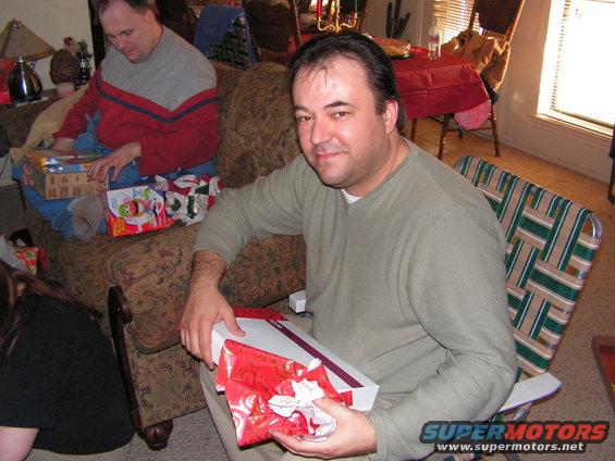 People opening Christmas gifts indoors
