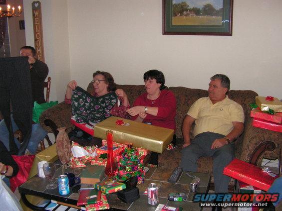People opening Christmas gifts in a living room