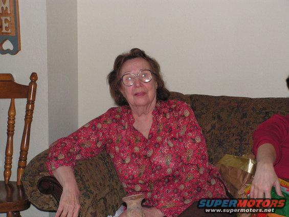 woman with glasses and floral shirt sitting on a couch