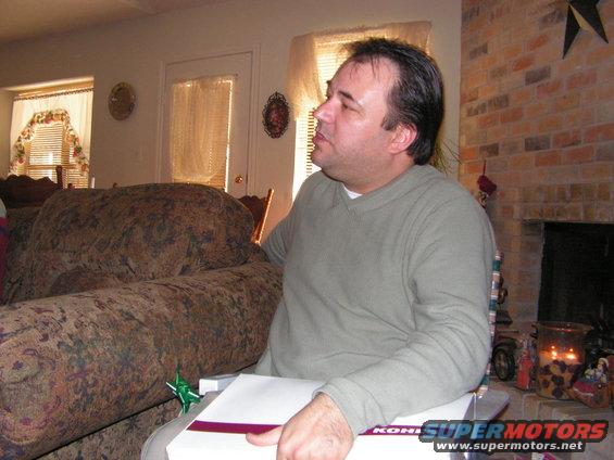 Man holding a gift box in a living room setting
