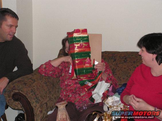 People opening Christmas gifts on a couch