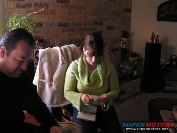 Man and woman sitting in a living room, looking at papers