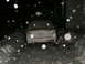 2000 Ford Taurus - A white 2000 Ford Taurus is seen from the rear, covered in snow during a winter night.