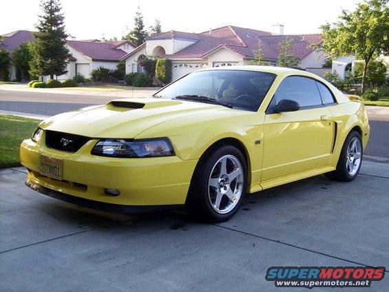 Yellow 2002 Ford Mustang parked on a driveway