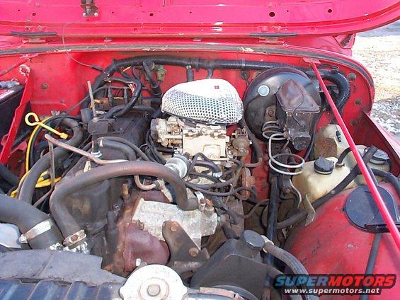 Red 1989 Jeep YJ engine bay with carburetor and air filter