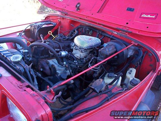 Red 1989 Jeep YJ engine bay with Edelbrock sticker