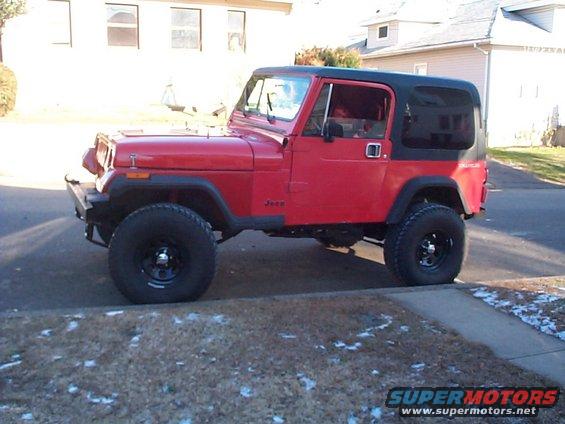 red Jeep CJ parked on street, black soft top