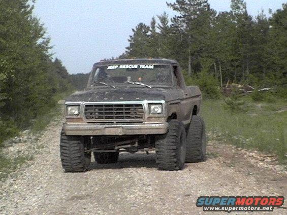 Lifted Ford pickup truck with large tires on a dirt road