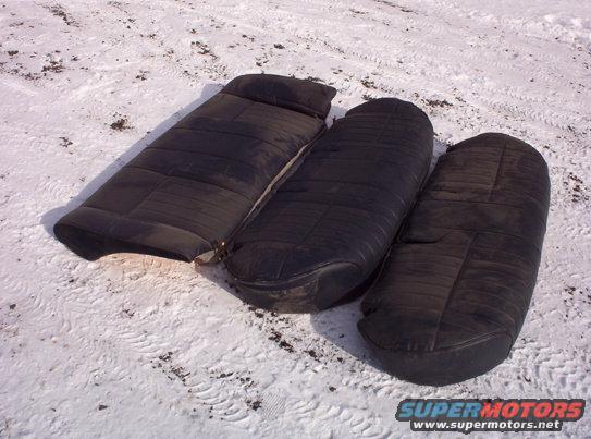 Three black car seats laid out on snowy ground