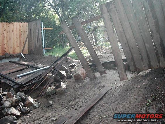 Construction site with debris and a broken wooden fence