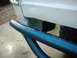 1978 Ford Bronco - Detail shot of a vehicle's rear end, showing a blue tubular bumper and white body panel.