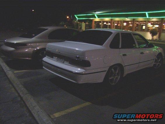 White 1995 Ford Taurus sedan, rear view, parked at night