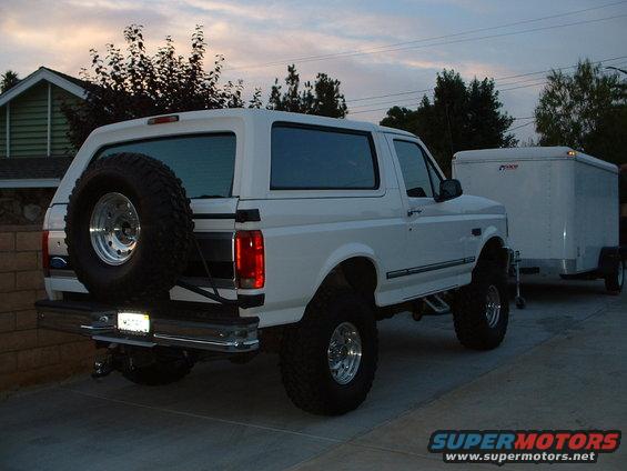 White 1995 Ford Bronco with external spare tire and trailer