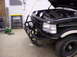 1993 Ford Bronco - A black Ford Bronco is shown with its hood up and a heavy-duty aftermarket bumper installed.