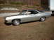 1971 Ford Torino - This two-tone coupe features a distinctive body style and is parked outdoors near a large trailer.